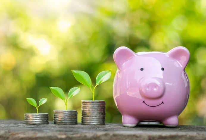 This is a picture of stacks of coins next to a piggy bank.